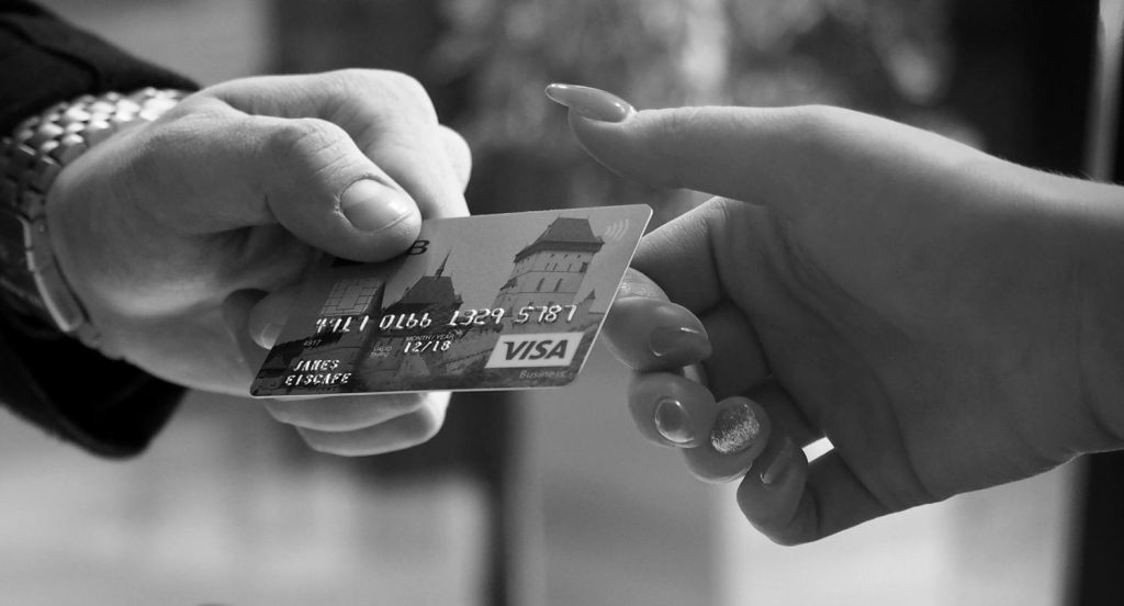 dłoń podająca kartę kredytową