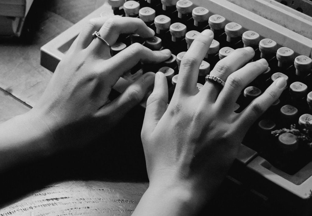dłonie na maszynie do pisania