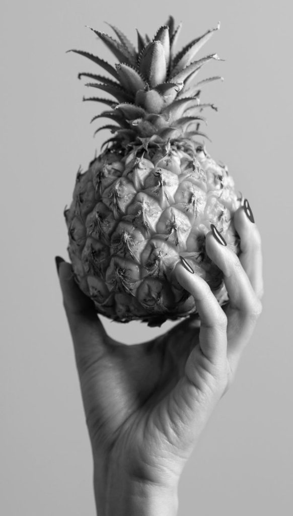 ręka trzyma ananasa