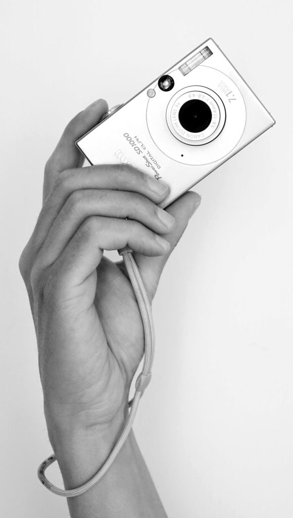 ręka trzymająca mały aparat fotograficzny